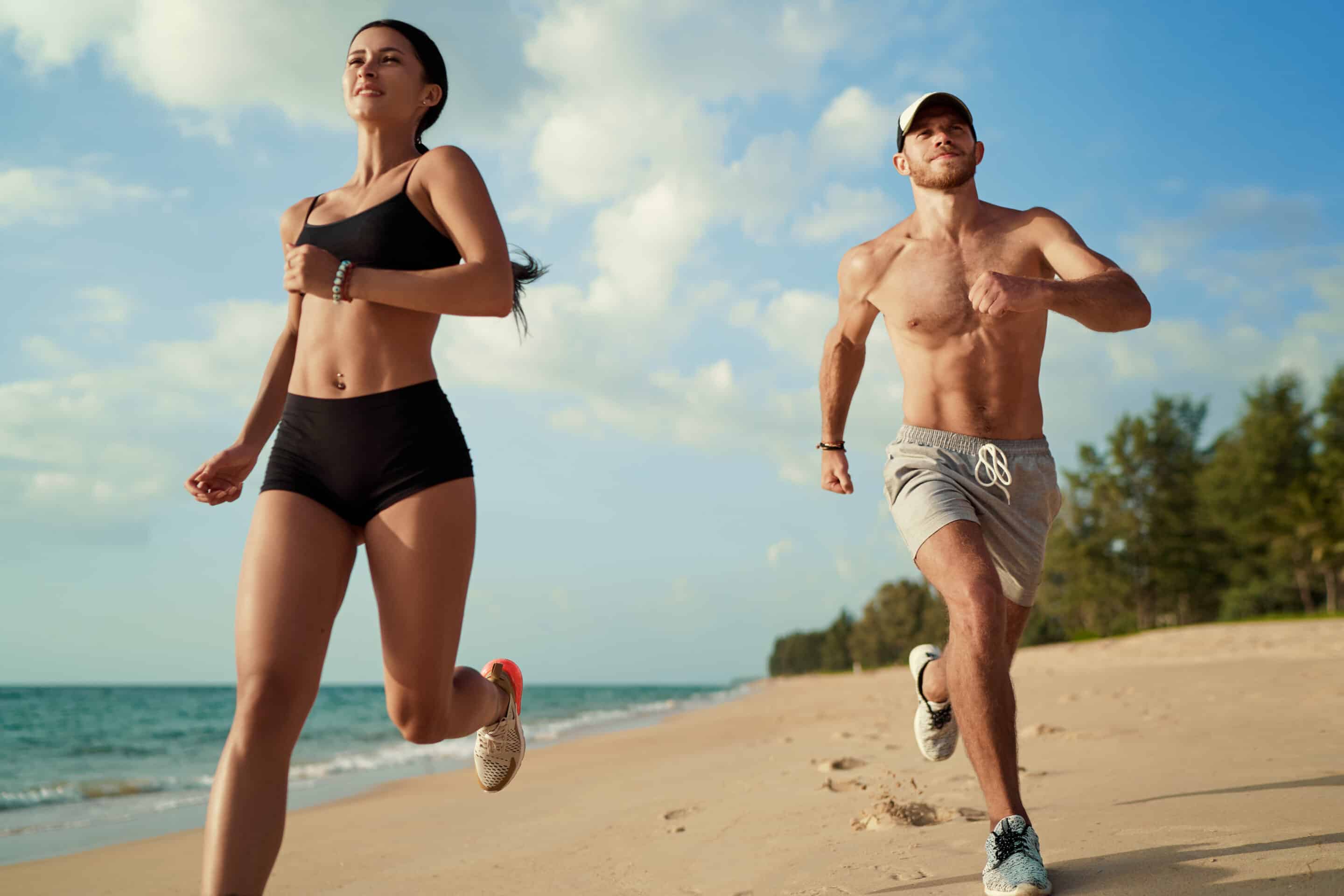 Couple running on the beach to get ready for summer.